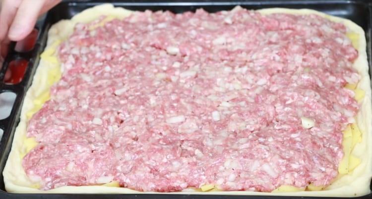 On top of the potatoes, spread the meat in an even layer.