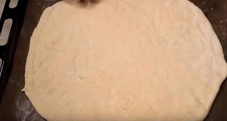 We shift the circle of dough onto a baking sheet covered with parchment.