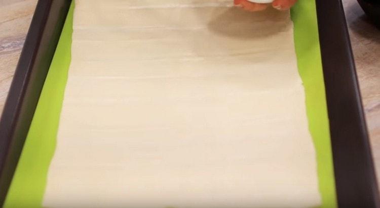 On a baking sheet we lay out a rectangular layer of the finished dough.