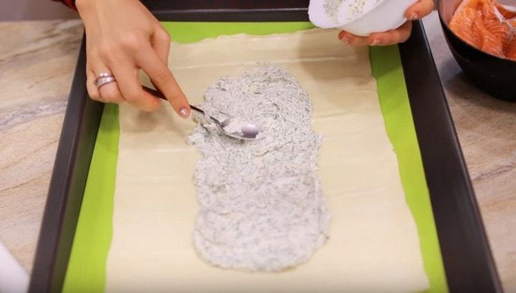 In the center of the pastry rectangle with a long, wide strip, spread Philadelphia cheese.