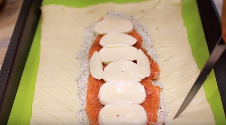 On the sides of the filling we make oblique cuts on the dough.