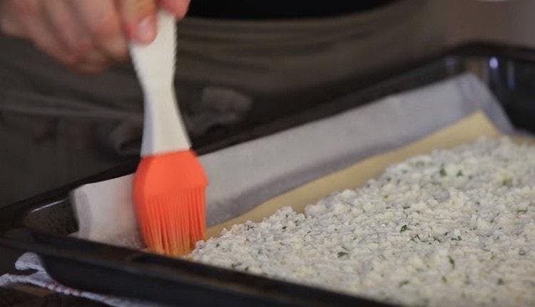 The edges of the dough are greased with whipped yolk.