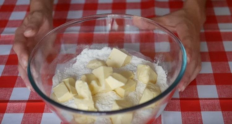 Sift the flour into a bowl and lay out pieces of cold butter.