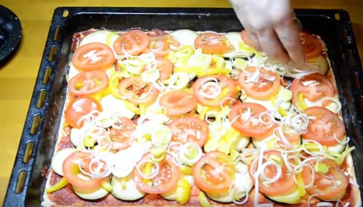 On top of the pepper we make a layer of tomatoes and sprinkle them with leek.