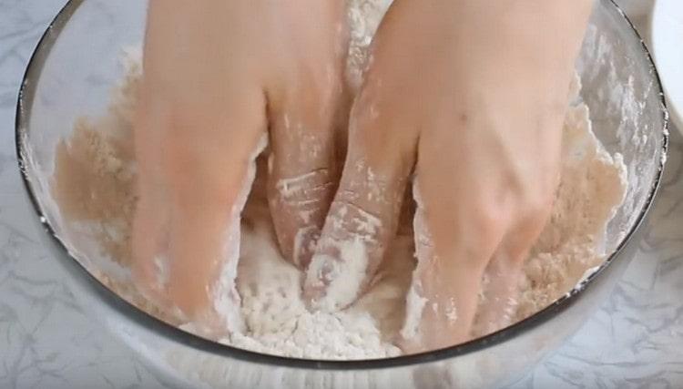 Hands grind flour with vegetable oil.