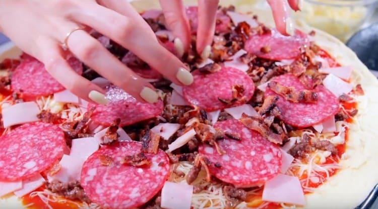 We spread the circles of salami nicely and sprinkle it all with finely chopped bacon, which we fried.