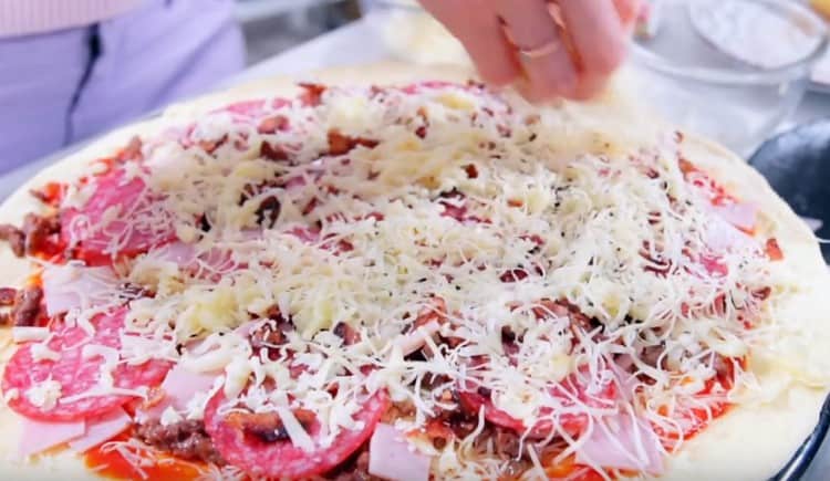 Sprinkle cheese on top of pizza.