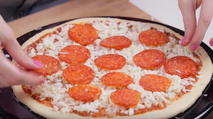 On top of the cheese layer spread the sausage.