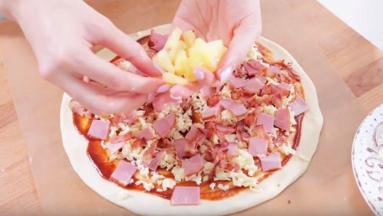 On top of the sauce we spread a piece of cheese, ham, pineapple, bacon.