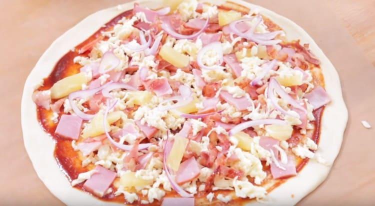 Sprinkle with the remaining cheese and lay out the onions.