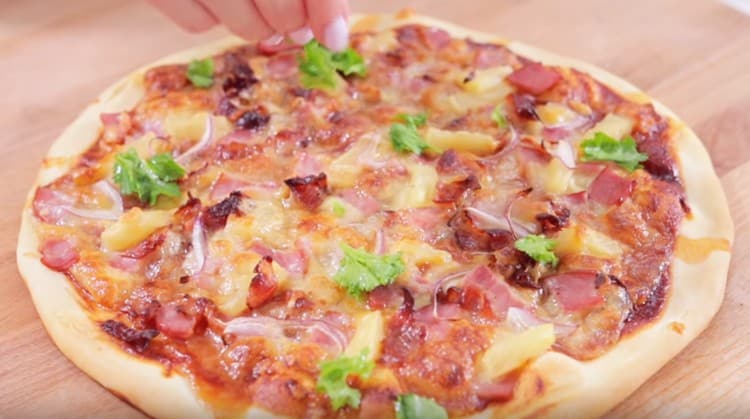 If desired, ready-made pizza with pineapple can be decorated with cilantro.