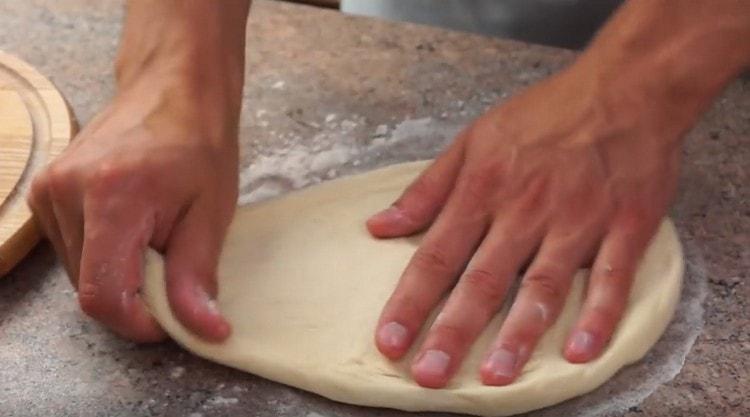 Stretch the dough with your hands or roll out.