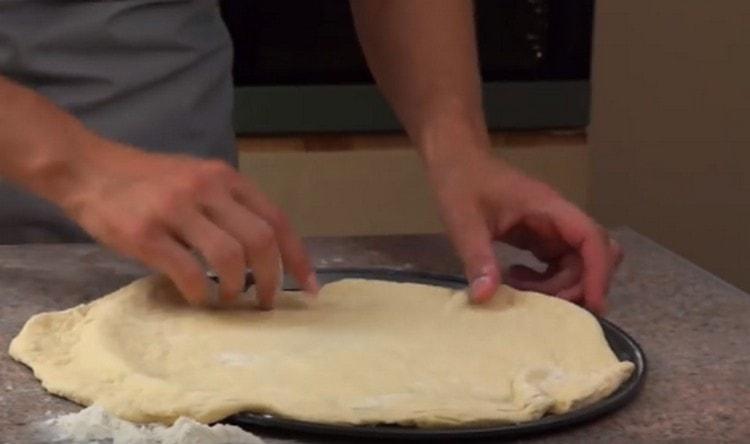 We spread the dough in a baking dish.
