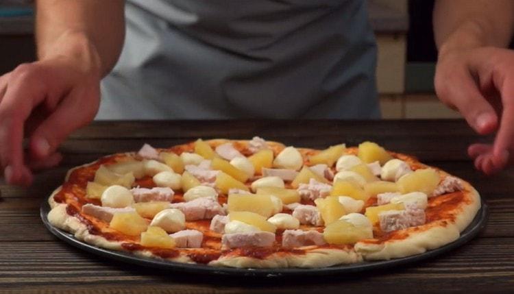 We lay out pieces of chicken and pineapple on a workpiece.