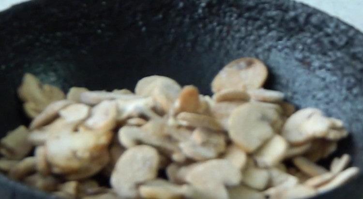 Mushrooms cut into slices and fry in a pan.