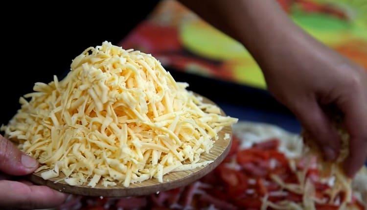 Sprinkle pizza with grated cheese.
