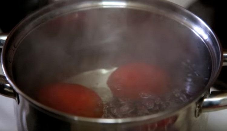 We spread tomatoes in boiling water.