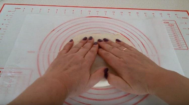 Stretch the dough with your hands, forming the basis for pizza.