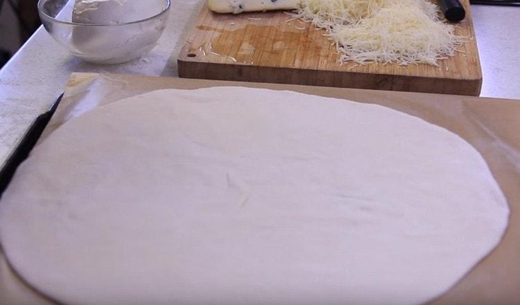 We spread the dough on a baking sheet covered with parchment.