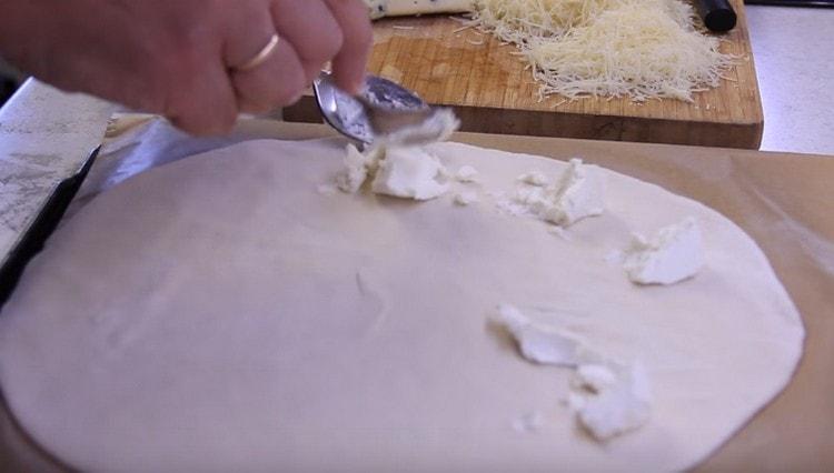First, put the ricotta on the dough.