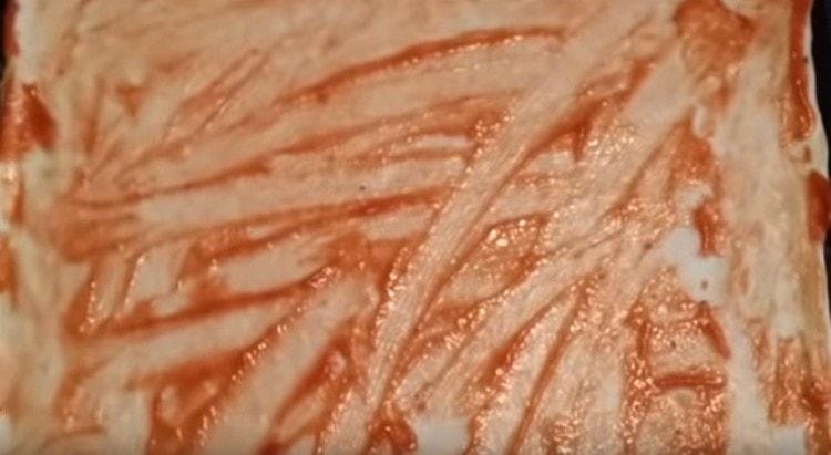 Grease the dough with ketchup or tomato sauce.