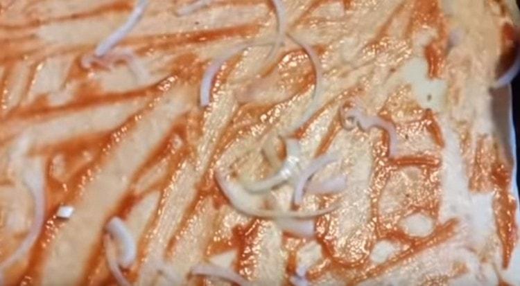 We spread the onion evenly on the basis of the pizza.