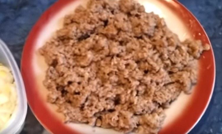 Minced meat is fried in a pan with chopped onions.