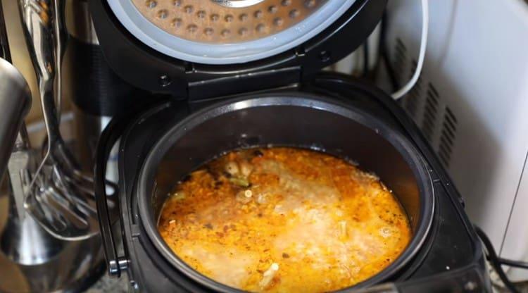 We distribute the rice with a spoon so that the water completely covers it.