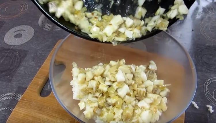 We prepare the filling by combining boiled rice with onions and fish.
