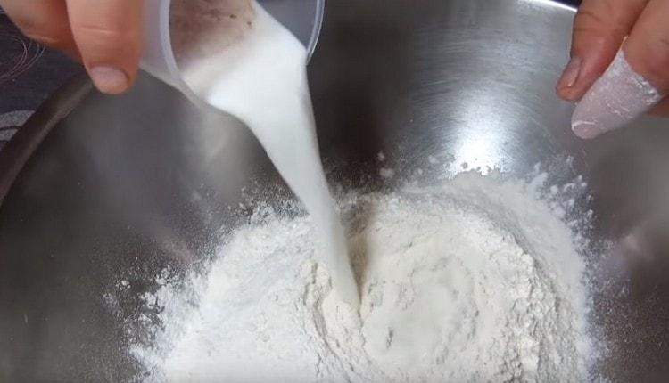 In the sifted flour, we introduce milk with yeast.
