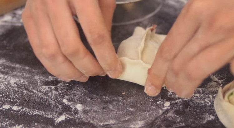 We pinch the edges of the dough and form manti.