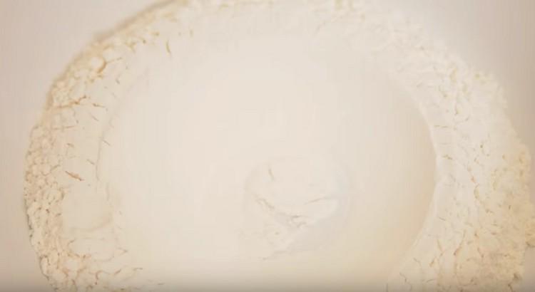 Sift the flour, make a depression in it.