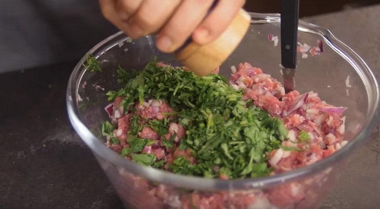 Add salt, pepper, chopped greens to the minced meat.
