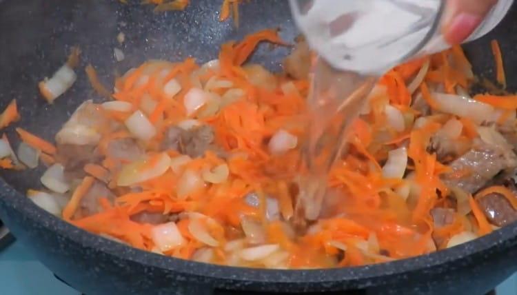 Pour water and leave the meat with vegetables to stew.