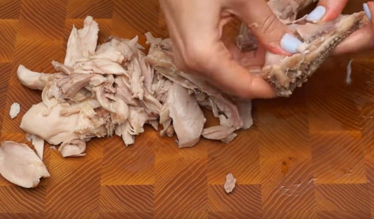 From the cooled legs, we separate the meat, cut it.