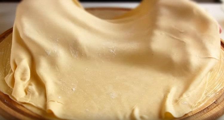 On a greased layer of dough, lay out the second one, grease with oil, and then lay out the third.