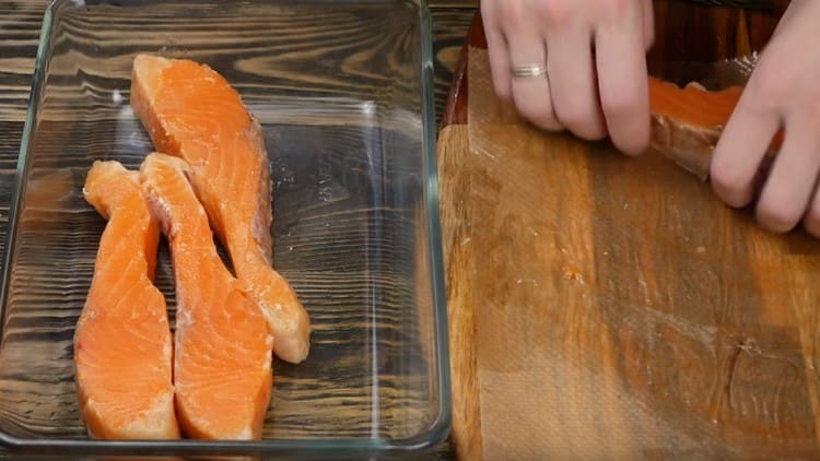 We spread the pieces of salmon with a baking dish with sides.