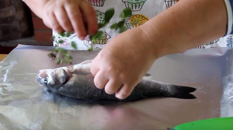 In the belly of the fish, laid out on the foil, put the fragrant herbs.