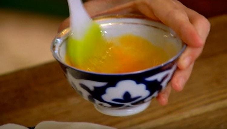 Lightly beat one egg yolk.