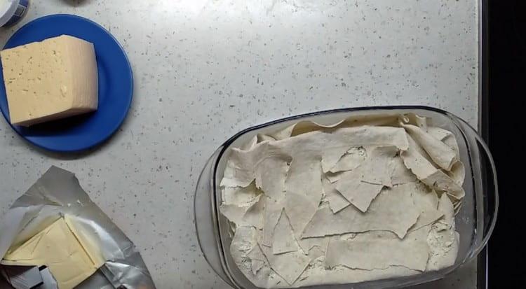 We cover the last layer of the filling with pieces of pita bread, which you just need to tear with your hands.