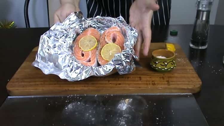 Put lemon on fish to cook trout steak in the oven.