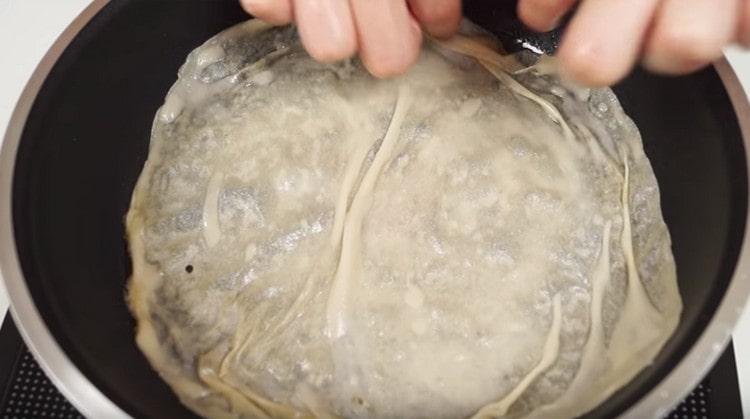 We spread the dough in a heated pan.