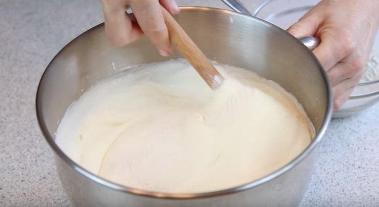 We introduce flour with starch into the egg mass, gently mixing everything with a spatula from the bottom up.