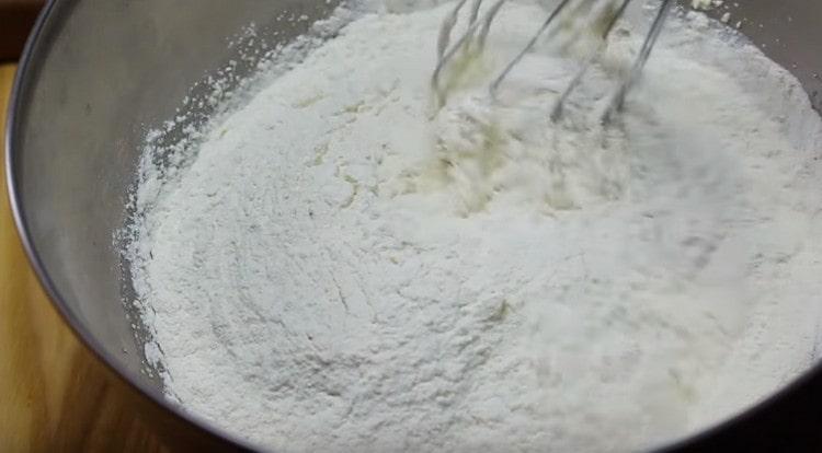 Little by little, we begin to introduce flour into the mass and knead the dough.