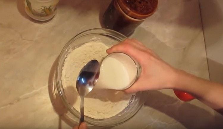 Add milk to the flour and begin to mix the mass with a spoon.