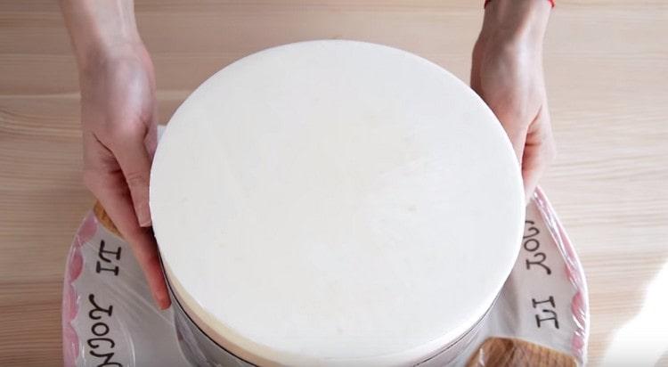 We take out the cake that is in the refrigerator from the mold, remove the film.