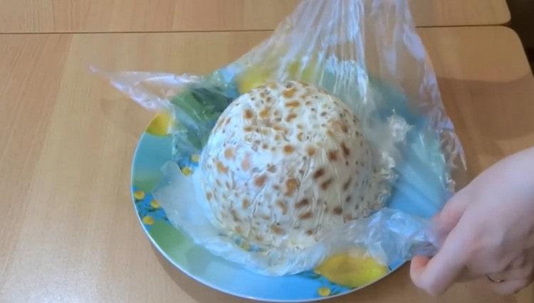 When the cake hardens in the refrigerator, gently turn it over to the dish and remove the cling film.