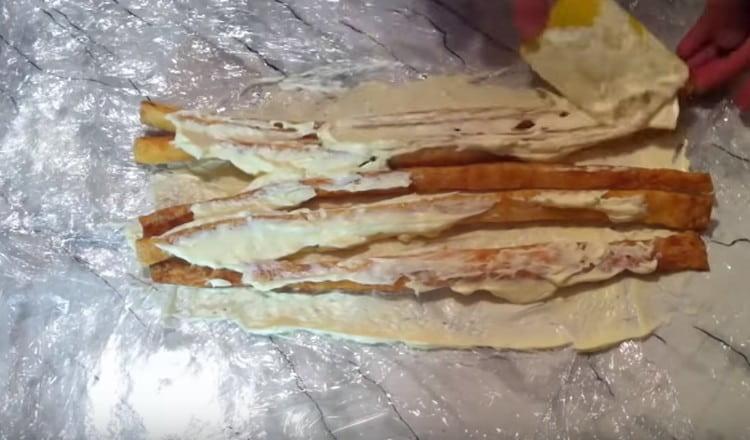 We spread the sticks in layers, smearing out the cream.