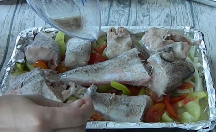 put the pieces of fish on top of the vegetables on a baking sheet and pour the marinade.