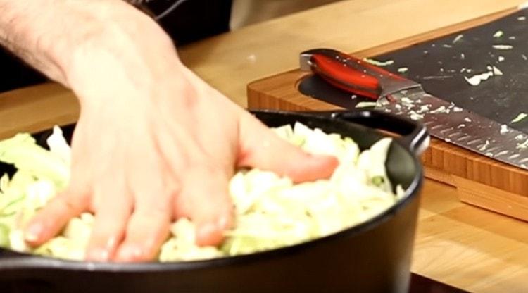 We spread the cabbage in a cauldron on top of the meat, until we mix.